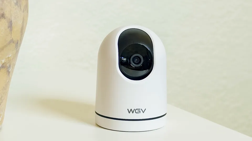 White pan-tilt security camera on a side table