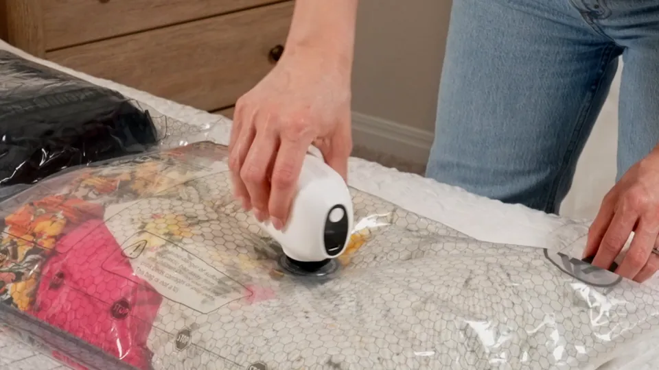 Hand using an electric pump on a travel vacuum bag