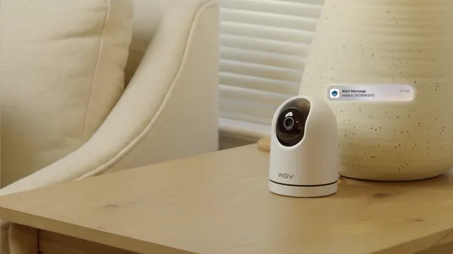 Pan-tilt security camera on a side table with an alert graphic