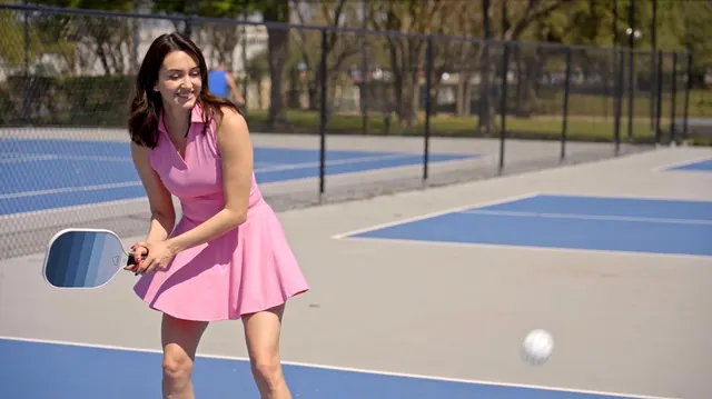 Model playing pickleball outdoors during a lifestyle product video shoot